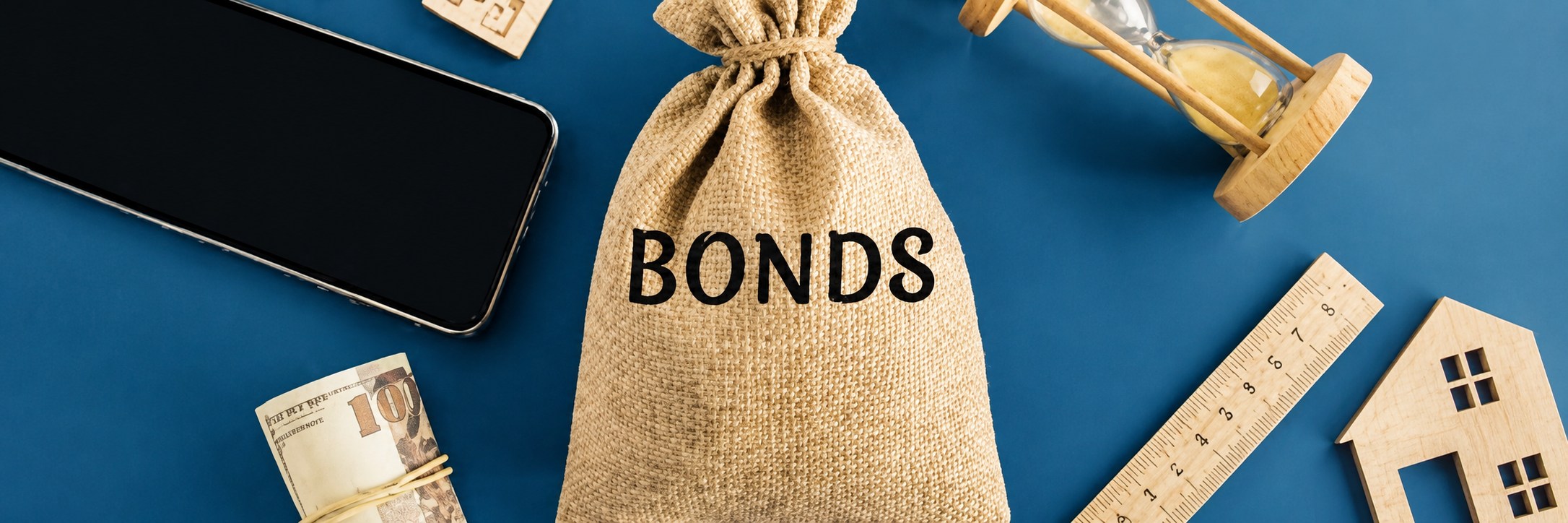 A desk displaying various bonds and stacks of money, illustrating financial assets and investment opportunities