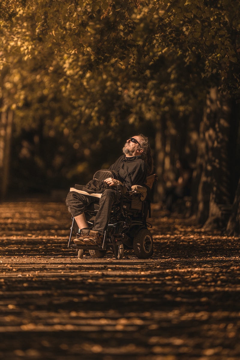 a man sitting in a wheel chair in a park