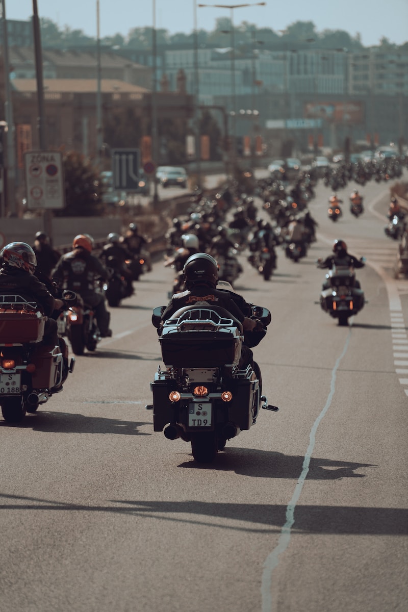 a large group of people riding motorcycles down a street