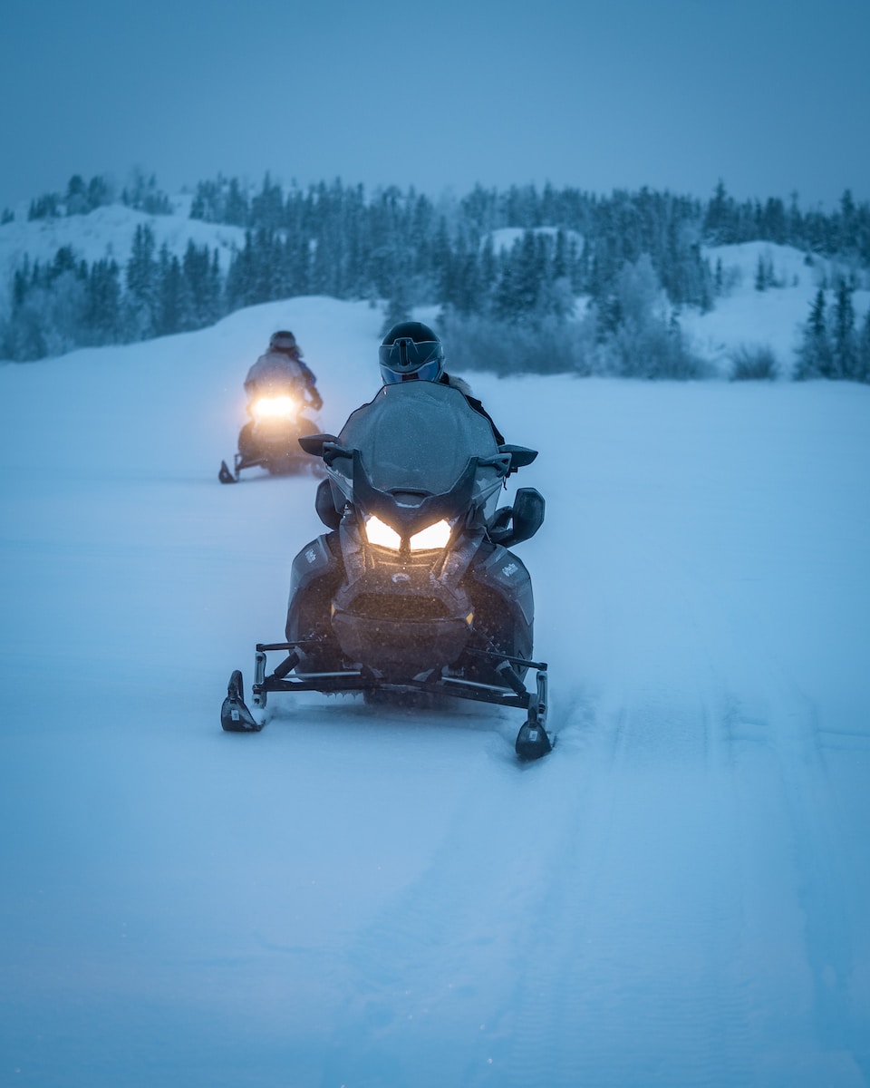 two persons riding snowmobile